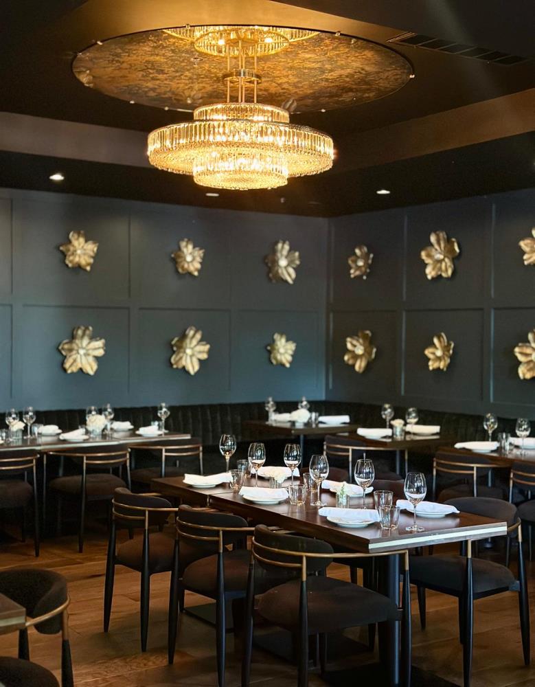 NYX Steakhouse dining room with gold chandelier and floral wall accents